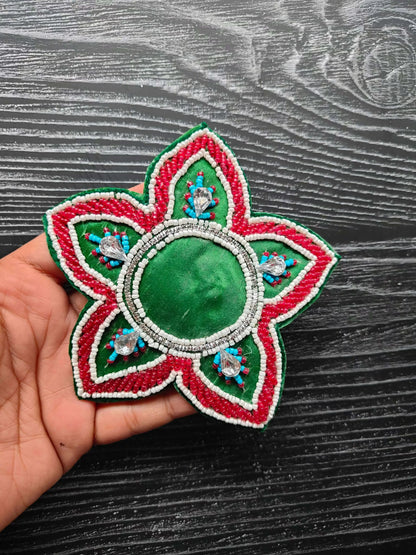 Green decorative patch with oval beaded center, red and white petal edges