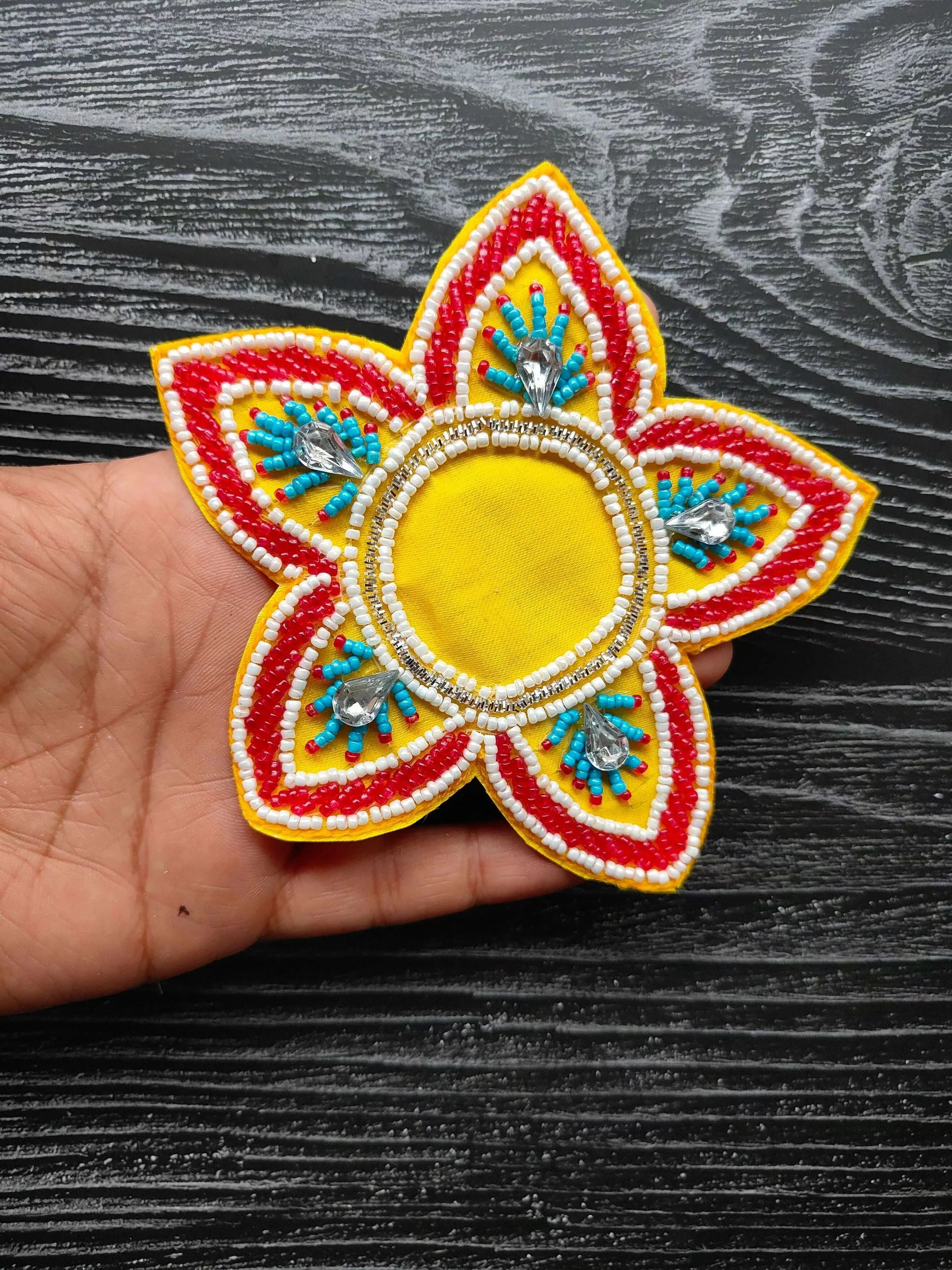 Yellow decorative patch with rounded beaded center, red/white petals and blue accents