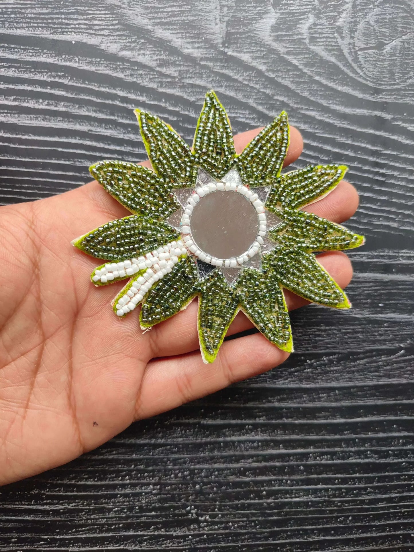 Beaded flower patch with dark green petals and round gray center.