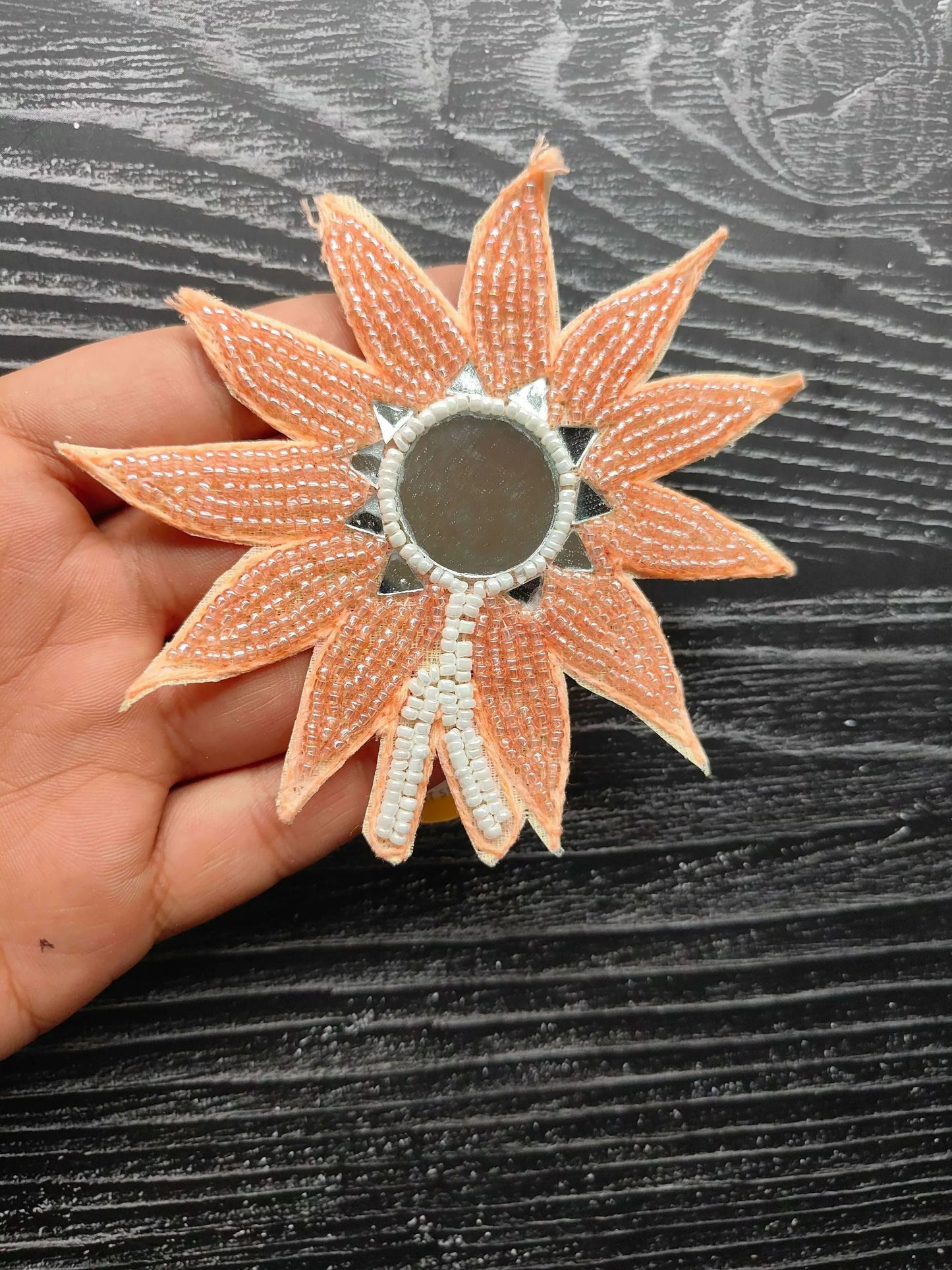 Beaded flower patch with peach-orange petals and round gray center.