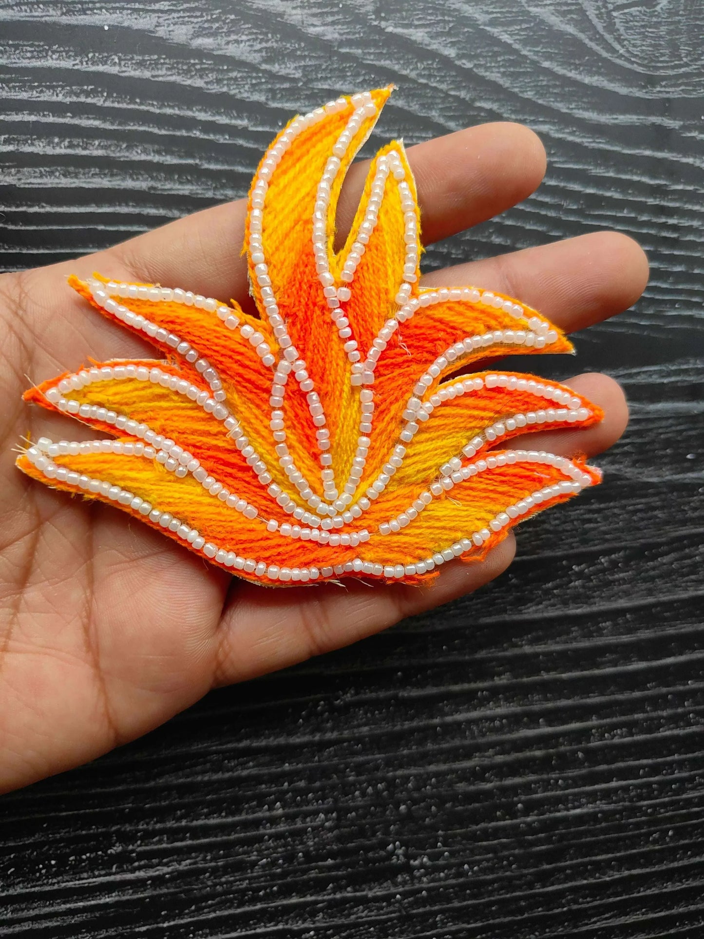Leaf-shaped decorative patch in orange/yellow with white pearl bead edging
