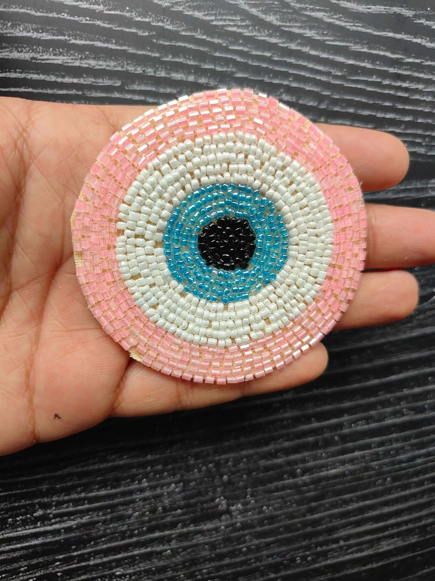 Pink circular beaded eye patch, white and blue rings with black center