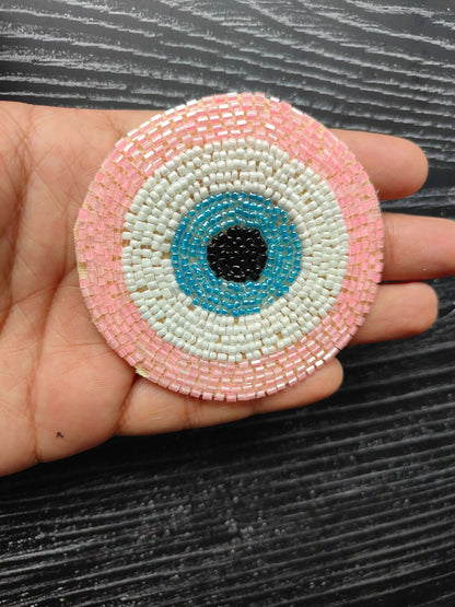 Pink circular beaded eye patch, white and blue rings with black center
