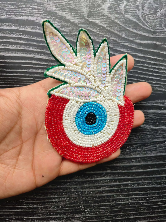 Decorative eye bead patch with green wings, red base, blue center eye