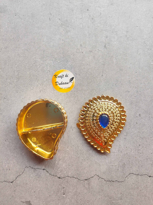 Elegant decorative roli chawal box in golden finish with intricate design and blue gemstone accent