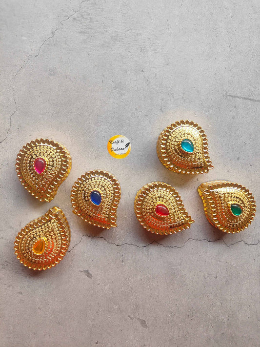 Set of six golden decorative roli chawal boxes with colorful gems for festive celebrations