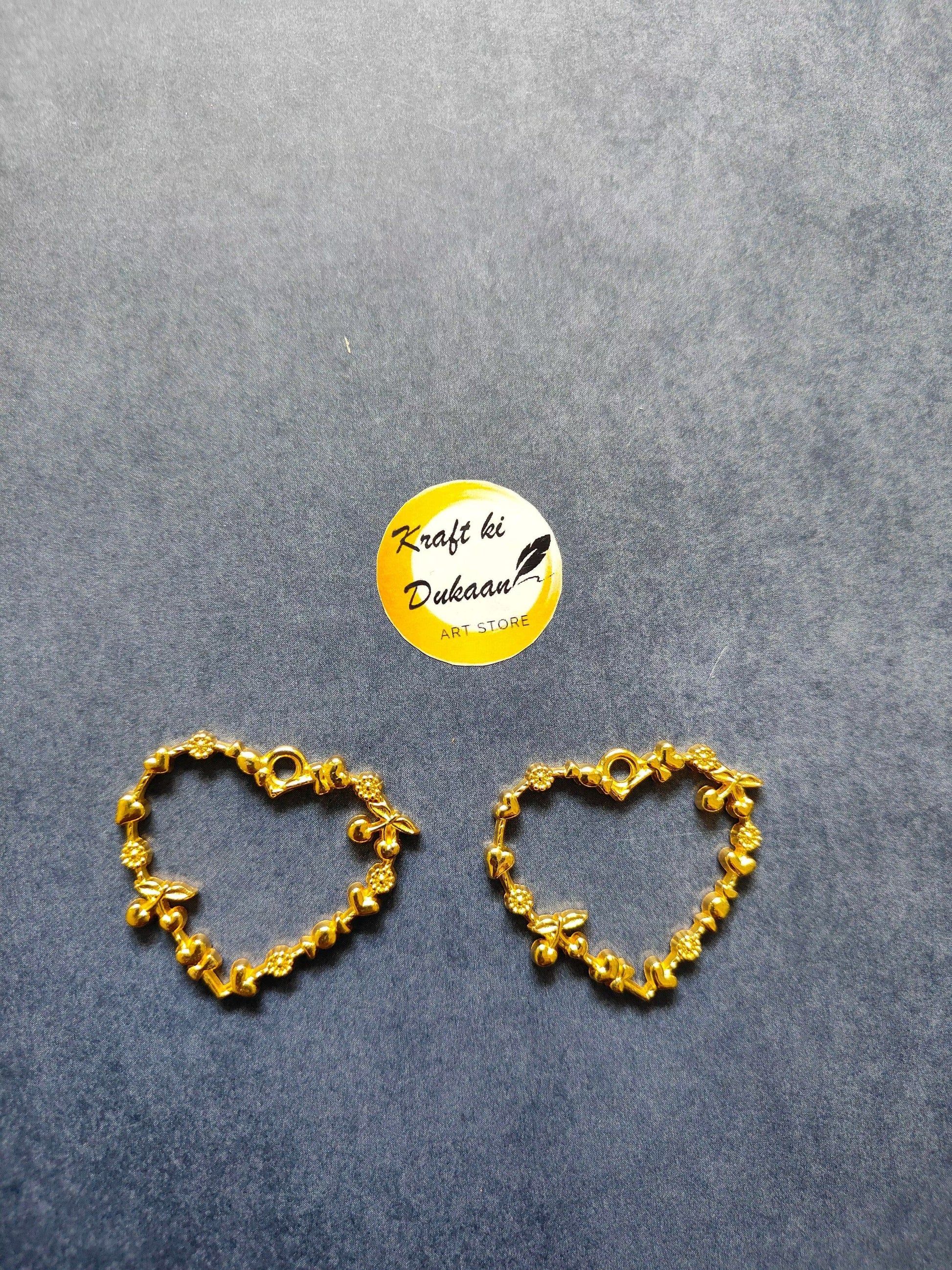 Gold tone heart bezel pendant pair with open heart design and dangling charms