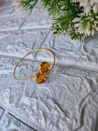 Gold designer bracelet with two round hammered discs on a thin bangle