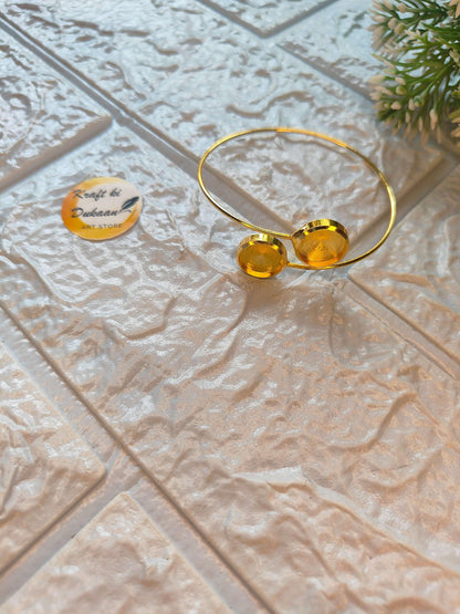 Gold-tone bangle bracelet with two round discs, open wire band