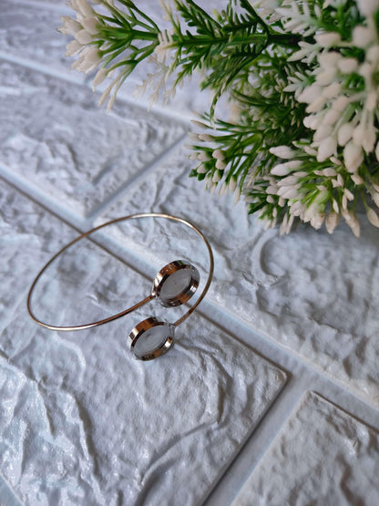 Silver-tone designer bracelet with two circular discs and a slim open bangle