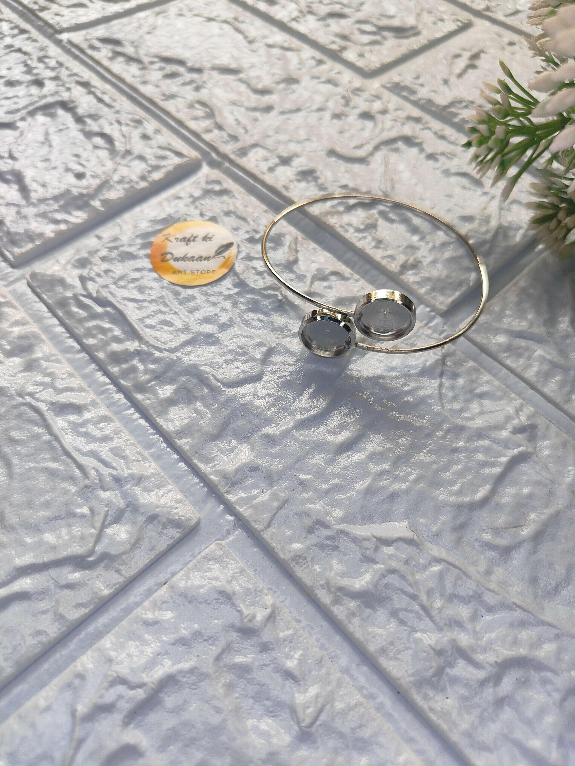Gold-tone bracelet with two round dark discs on a thin open bangle