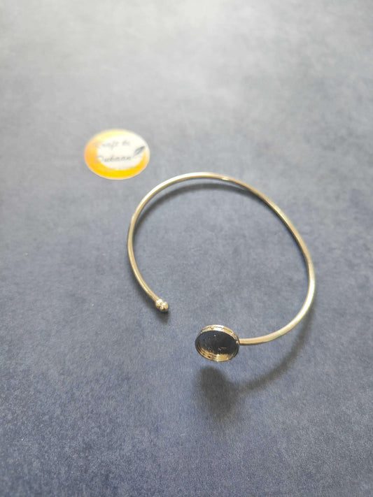 Gold-tone bangle bracelet with small bead clasp and round medallion