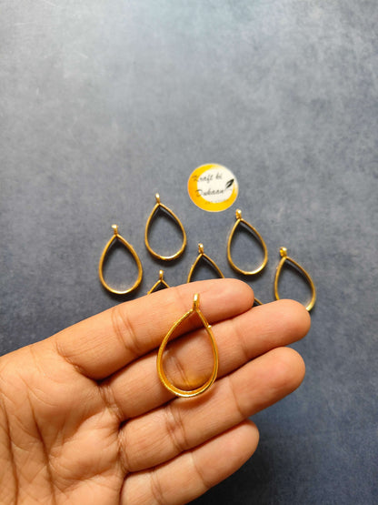 Gold teardrop drop bezel pendant charm held in hand, part of 10pc set