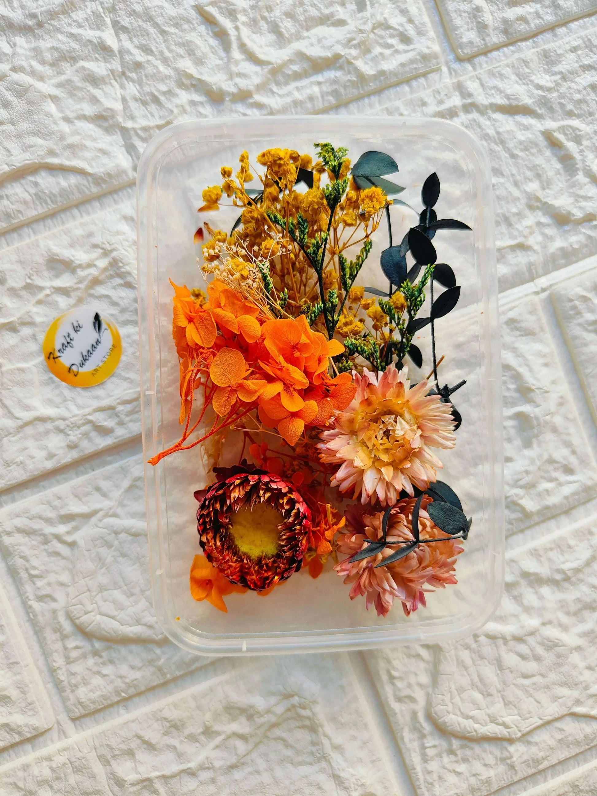 Dry Flower Box C15 with orange and yellow preserved blooms, dark foliage inside clear lid
