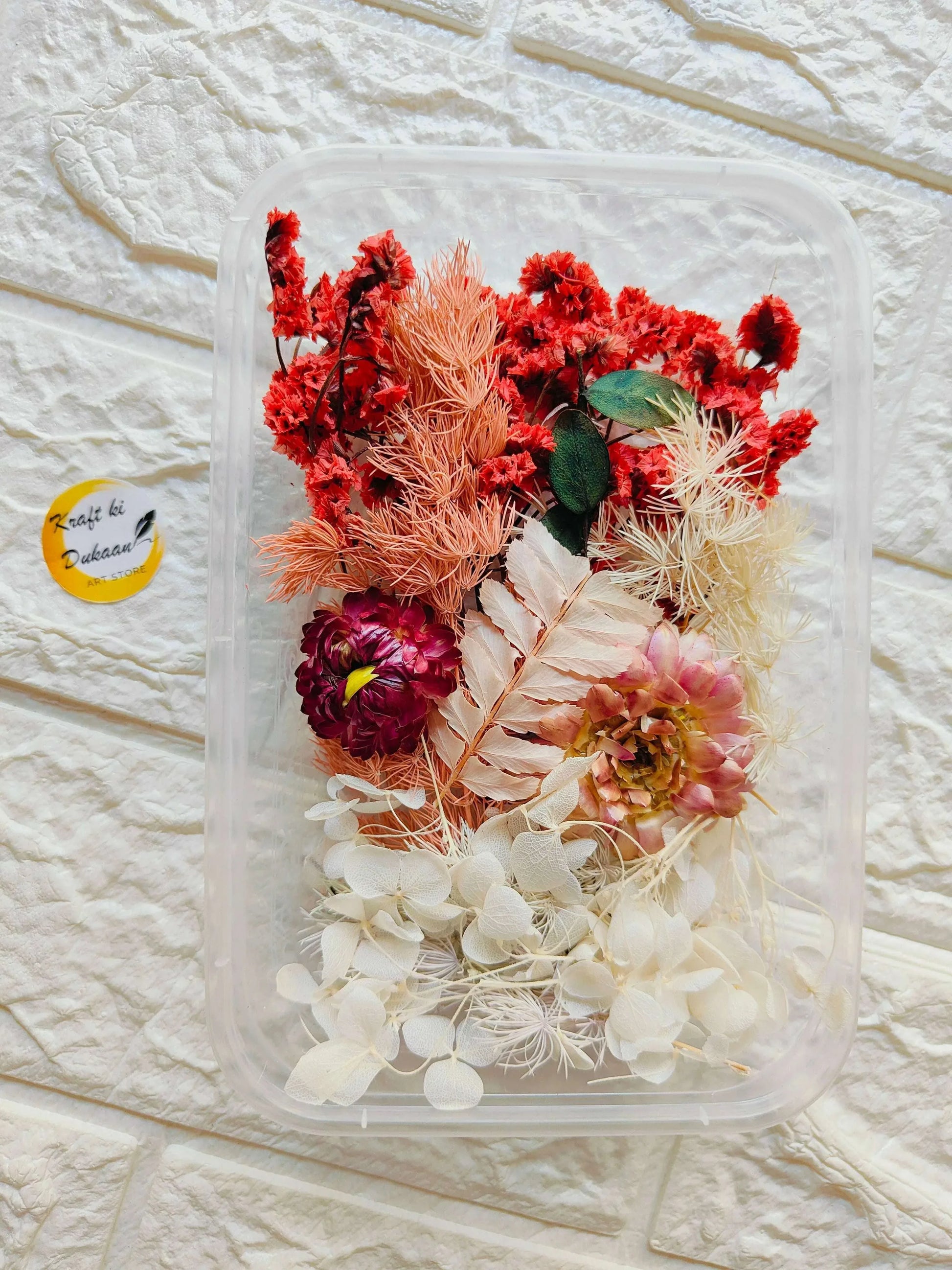 Dry flower box with red, peach and white dried blooms in clear plastic case
