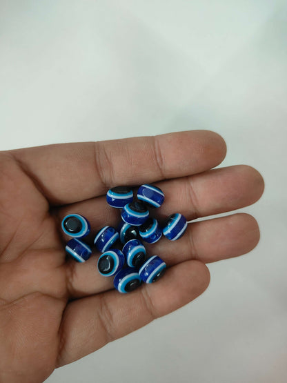 Blue oval evil eye beads with black center rings, 25-pack in hand