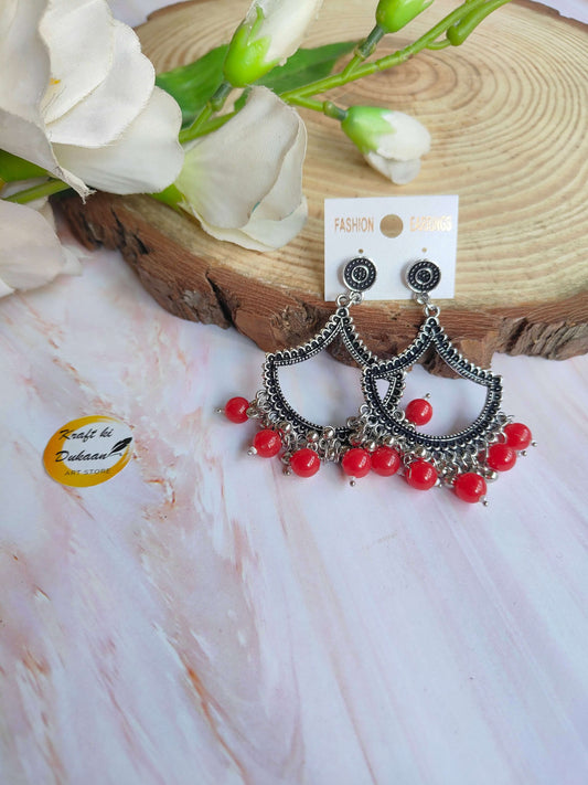 Beautiful silver jhumka earrings with red beads, perfect for festive or casual occasions