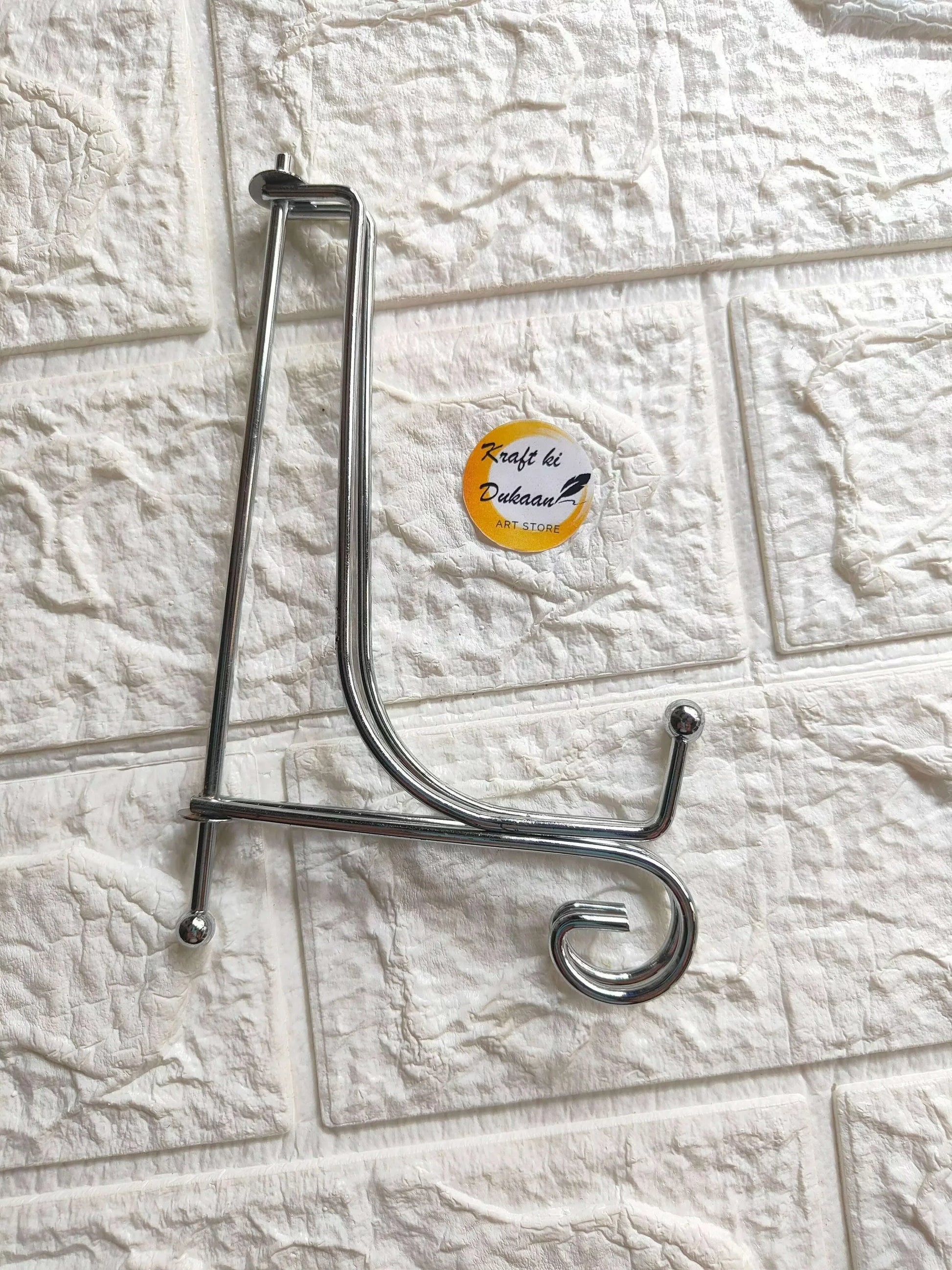 Foldable silver metal stand with curved hooks and base legs