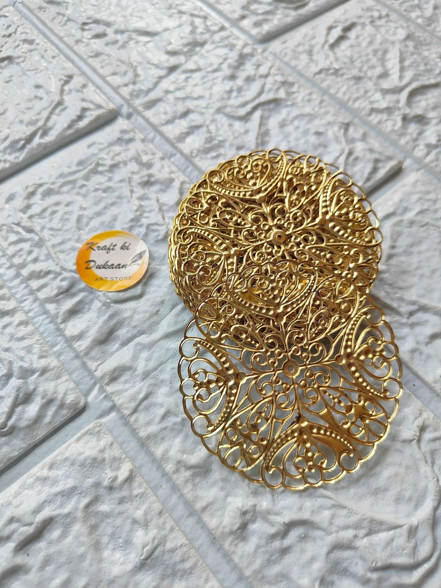Gold-toned filigree t-light plate with intricate circular floral lattice pattern