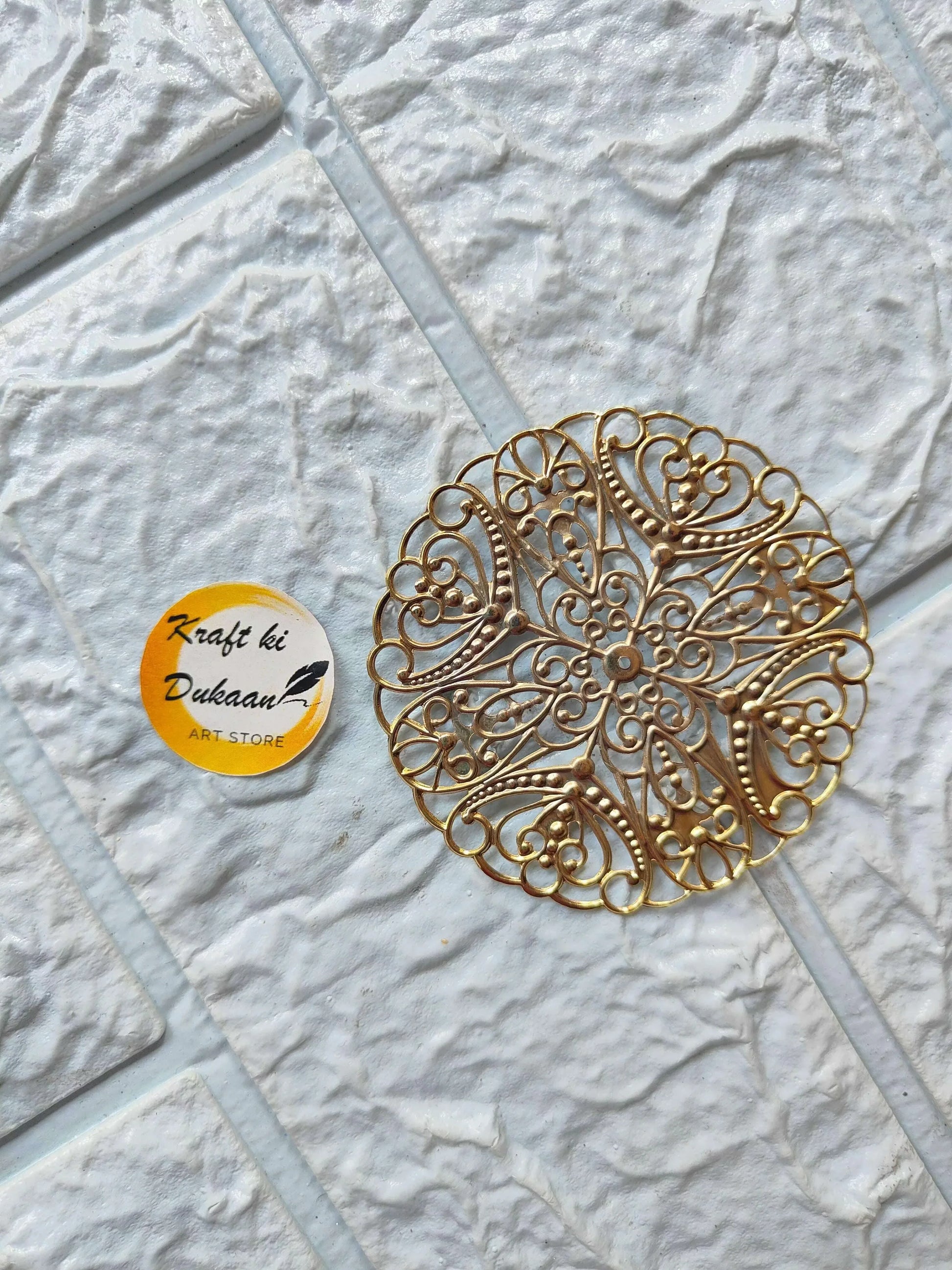 Golden round t-light plate with ornate filigree cutouts, flat metal design