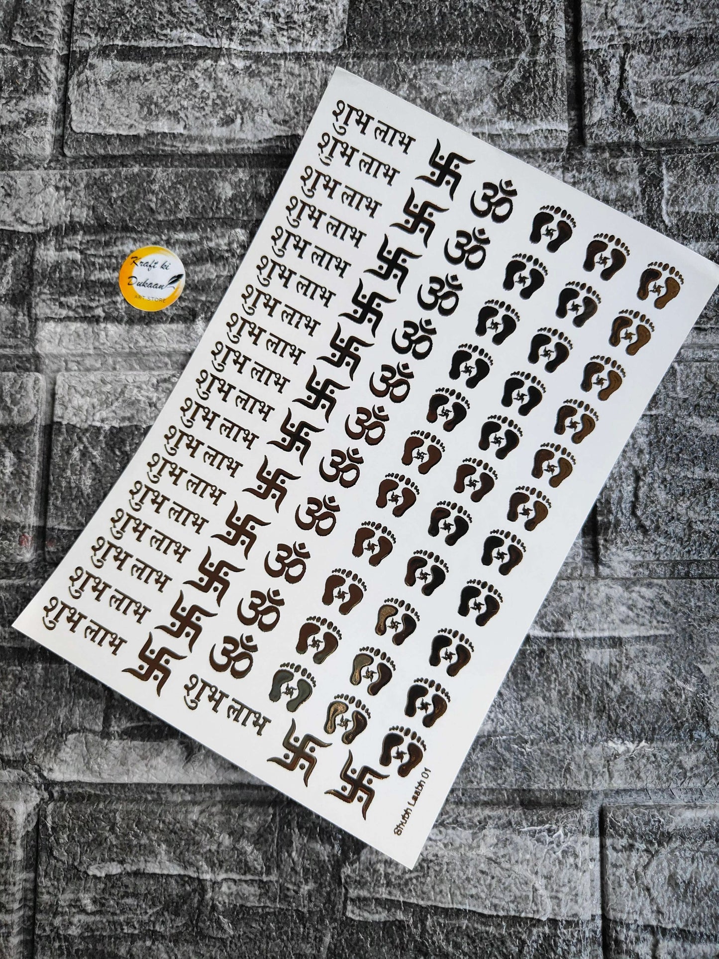 A5 gold embossed sticker sheet with Om symbols, footprints, and Hindi script