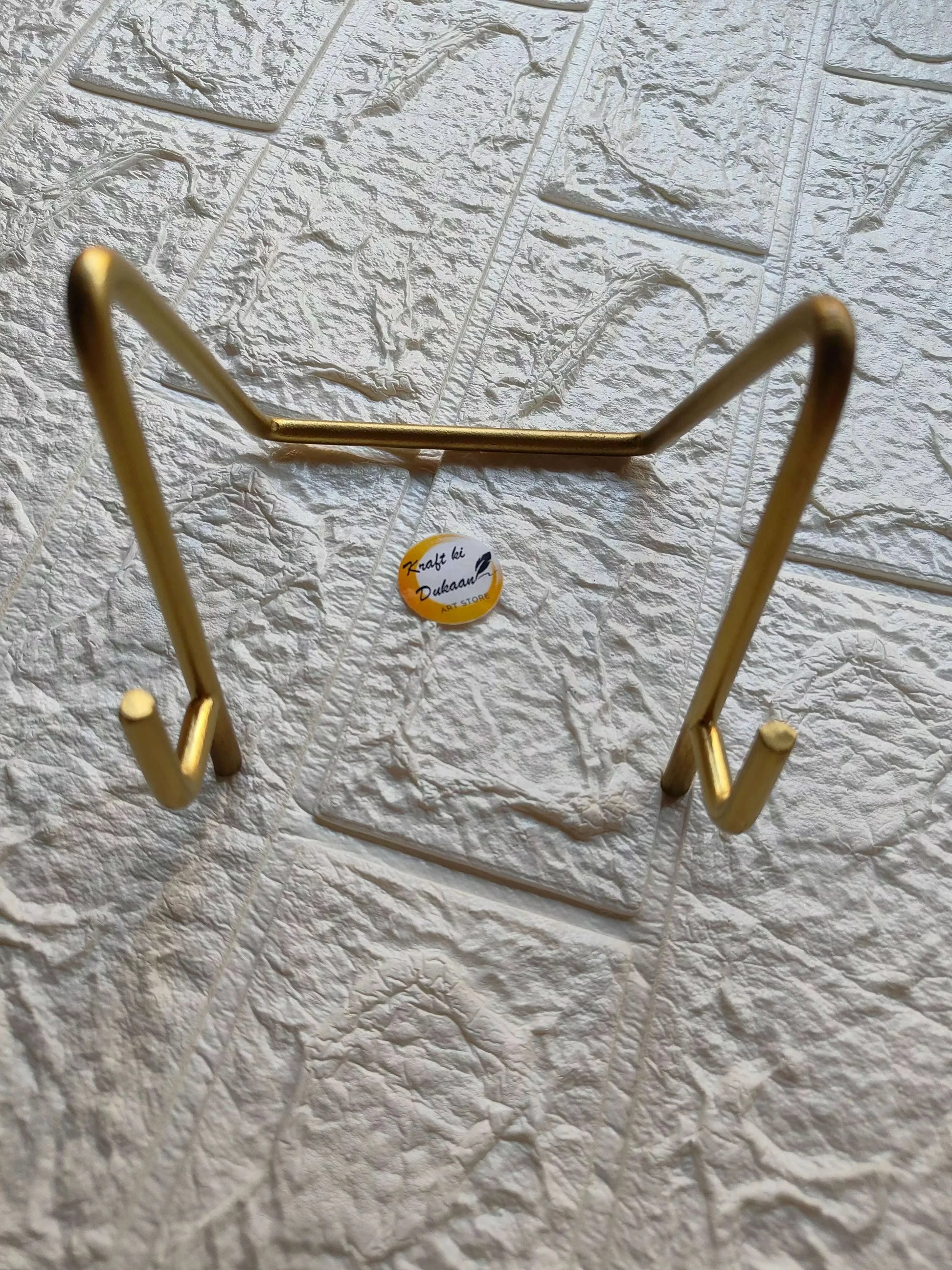 Golden metal stand with curved top bar and two side hooks for hanging