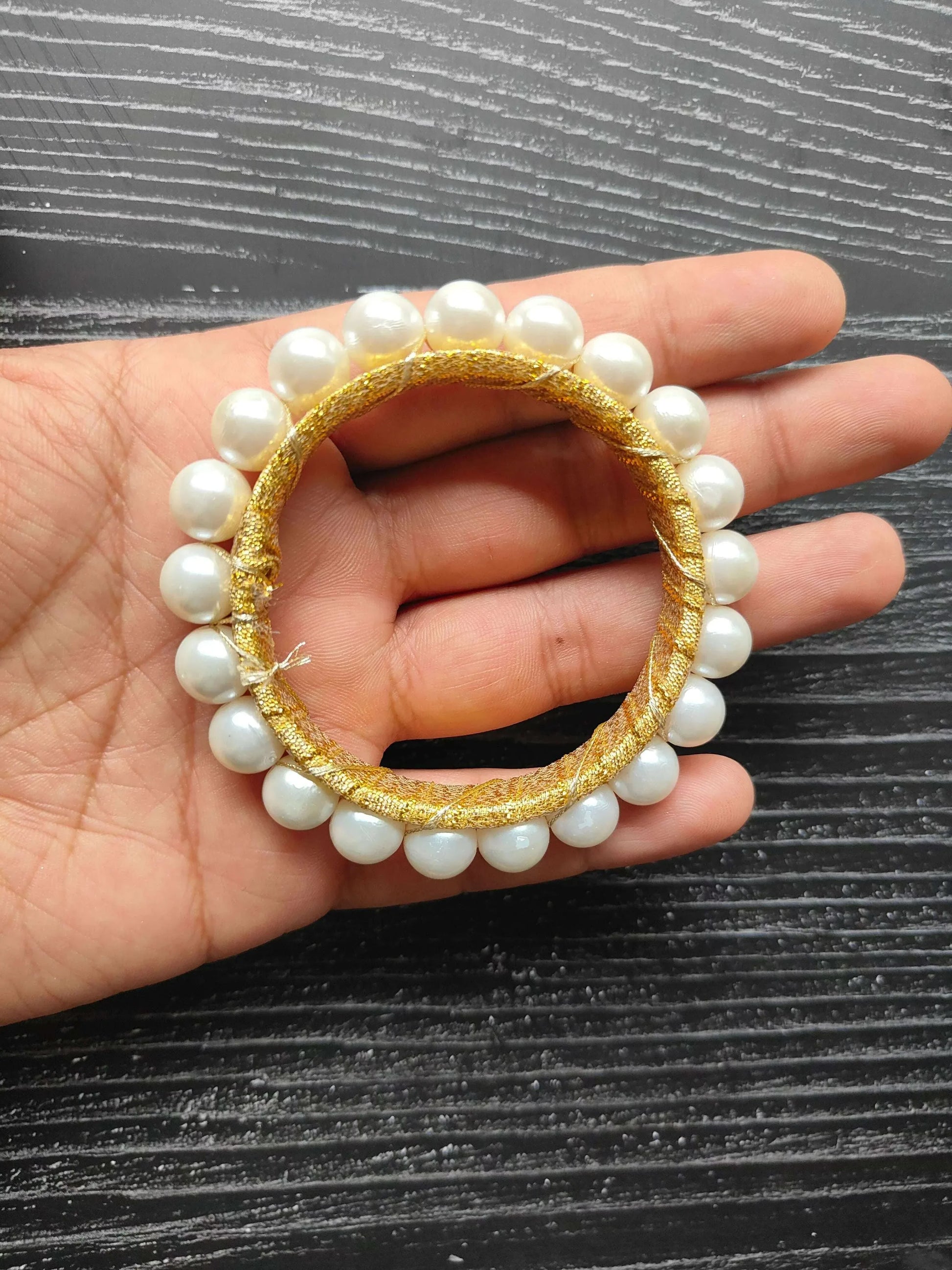 Gota pearl ring on hand: white pearls with gold woven circle