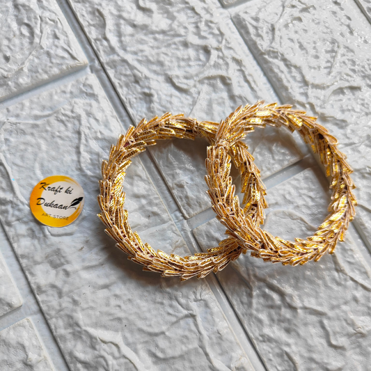Two golden gota wrapped rings for crafting placed on textured surface from Kraft ki Dukaan