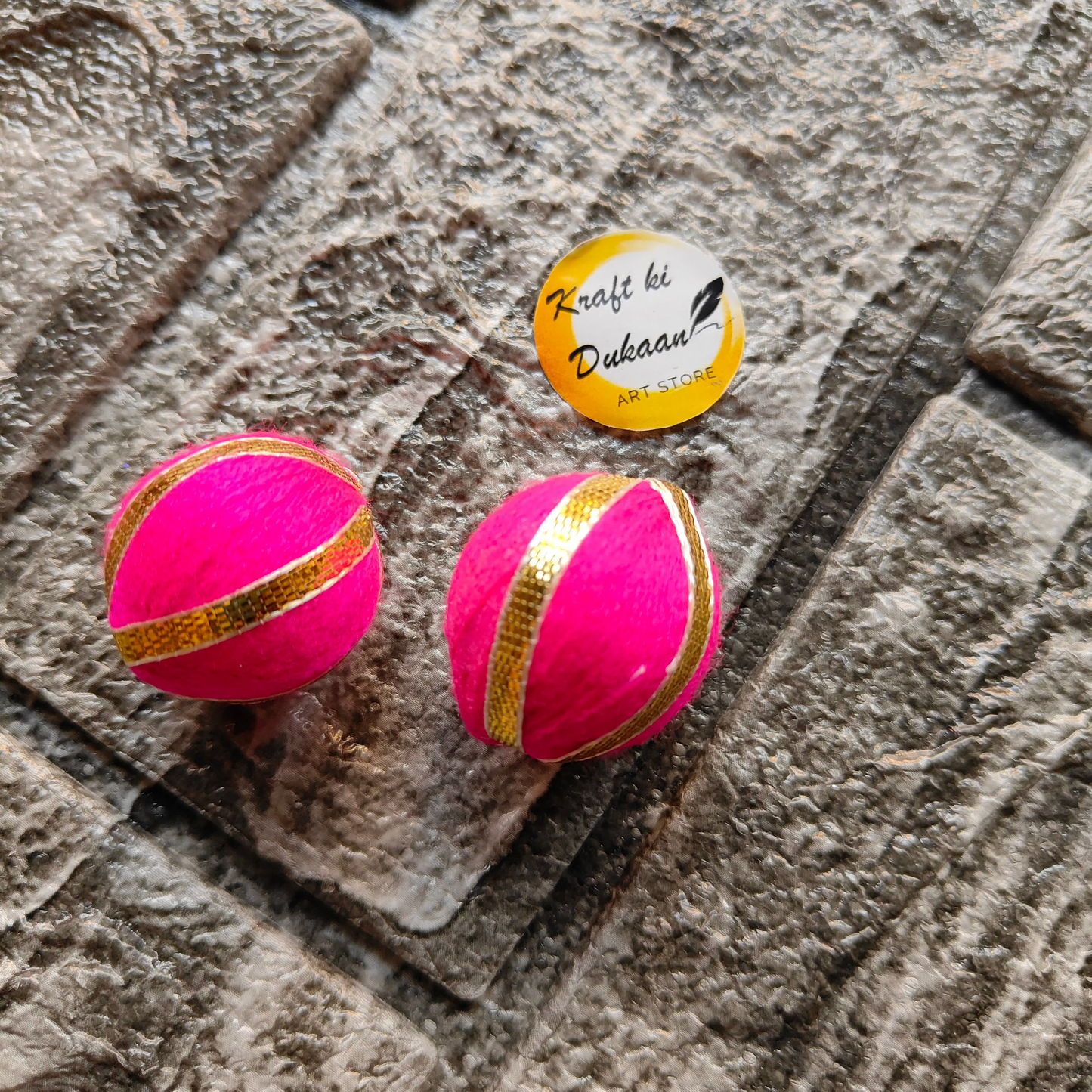 Bright pink Gota Patti craft balls with gold ribbon accents for decorative use