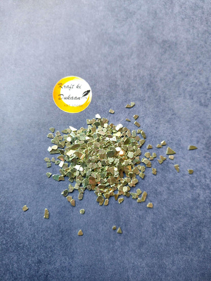 green-crystal-chips-for-resin-art-pile-on-blue-background