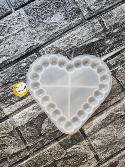 Heart bubble dish mould with cross divider and raised bubble edges, white.