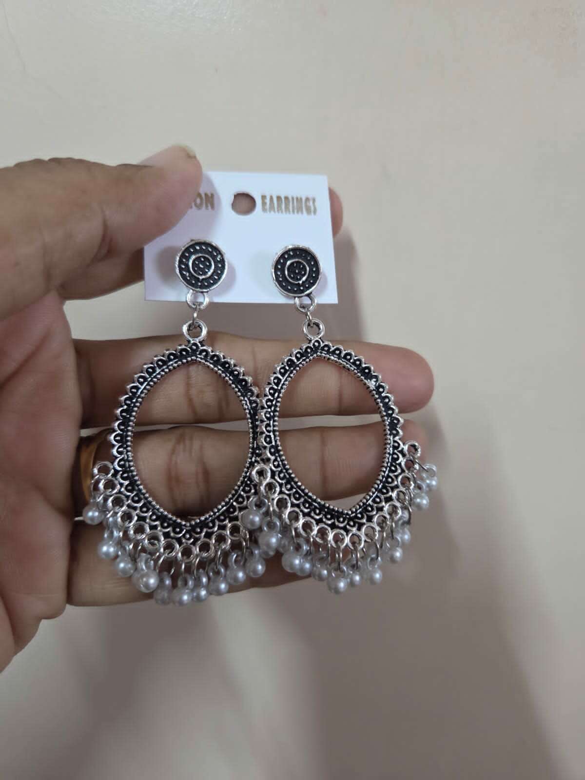 Silver eye-shaped jhumka earrings with small beads and dangling pearl-like drops
