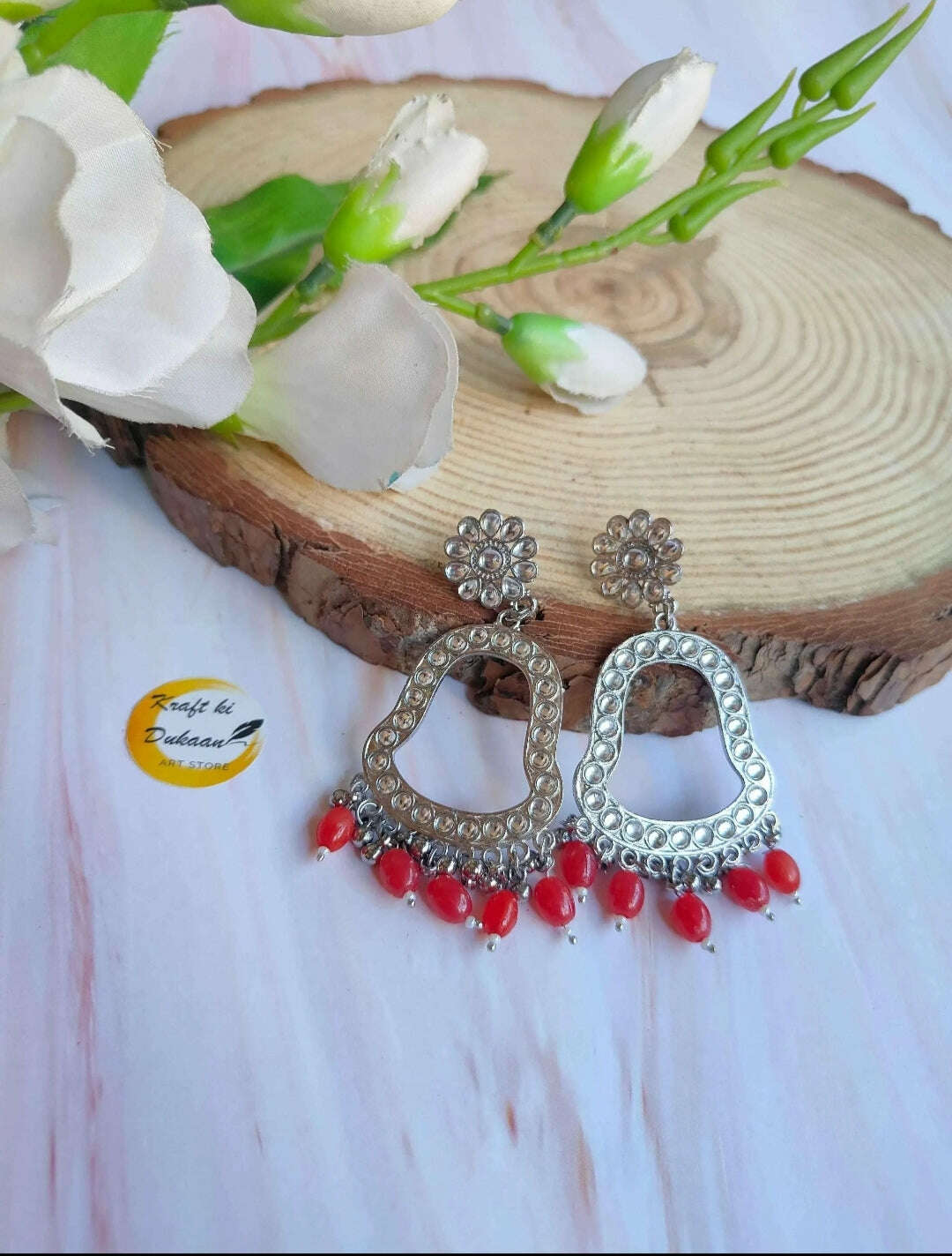 Jhumka drop earrings with silver-toned hoops and red bead drops