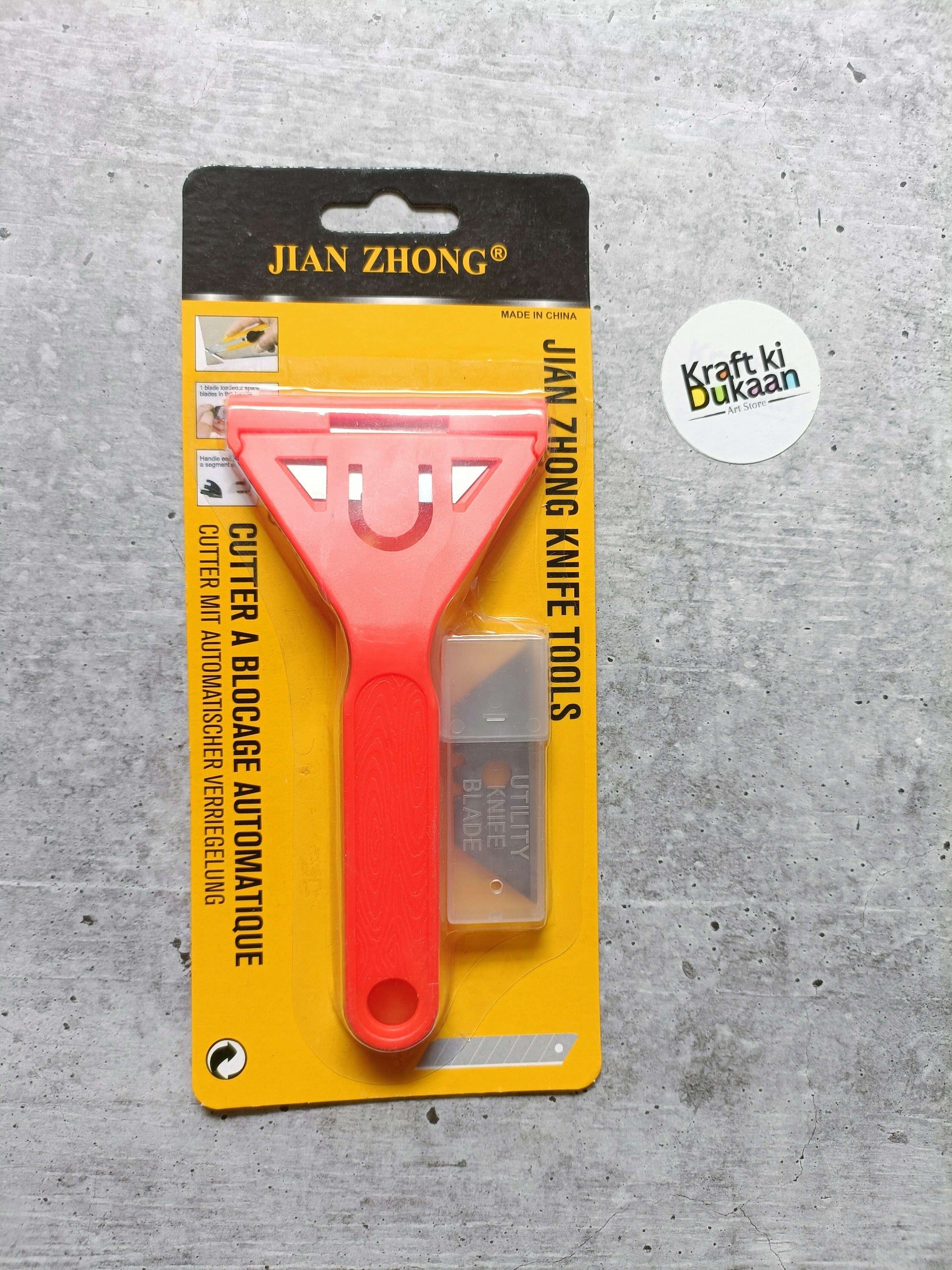 Knife tool with blades, red handle and metal scraper blade on card