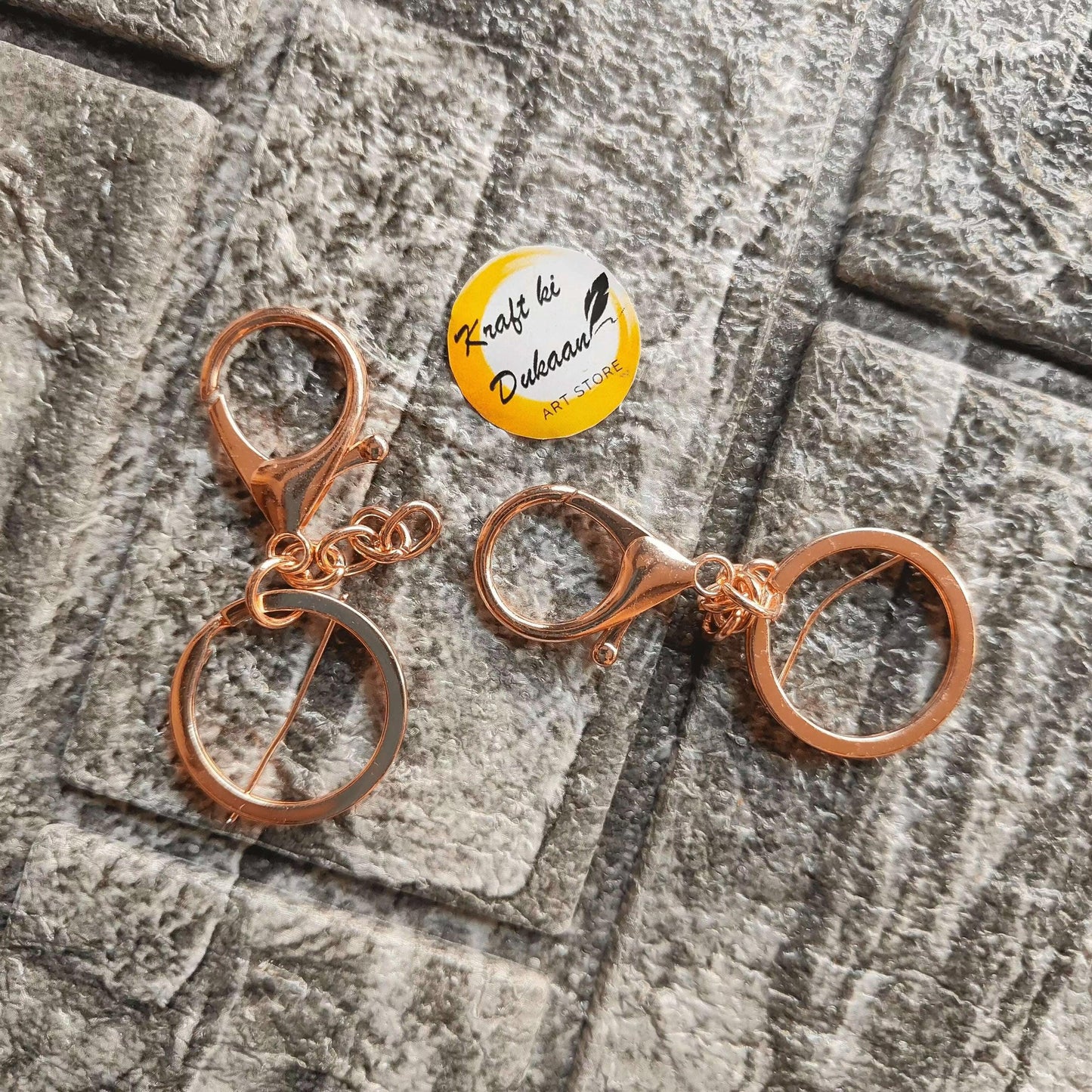 Rose gold-tone lobster clasp keychain, two circular rings connected by clasp chain