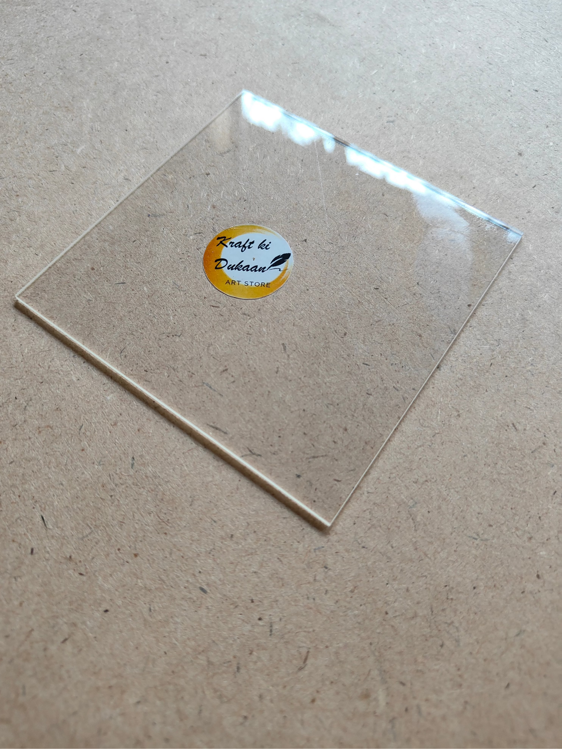 Clear 4 inch acrylic sheet for crafts by Kraft ki Dukaan placed on a wooden surface