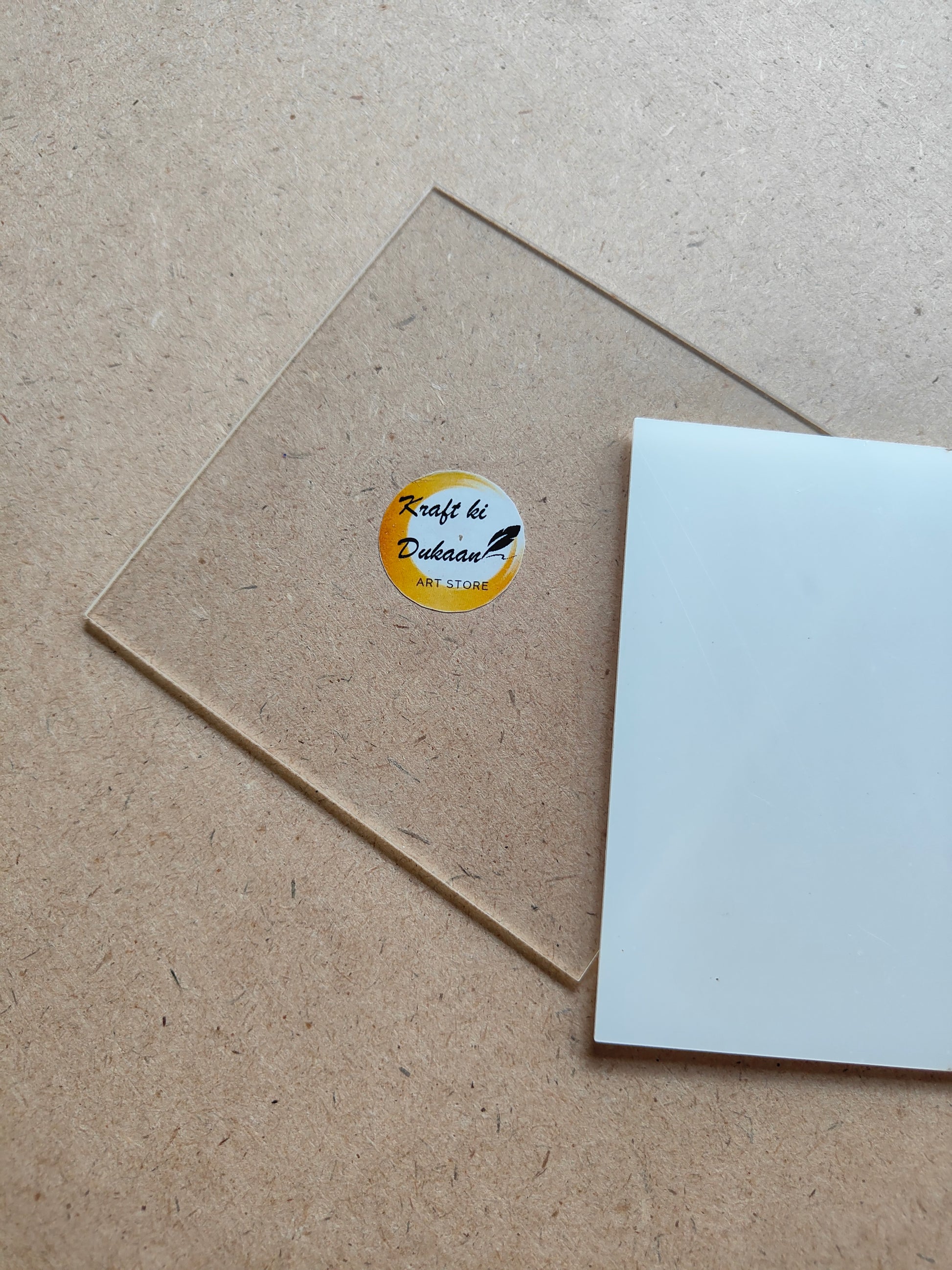 Clear 4 inch acrylic sheet for crafts from Kraft ki Dukaan placed on a textured surface