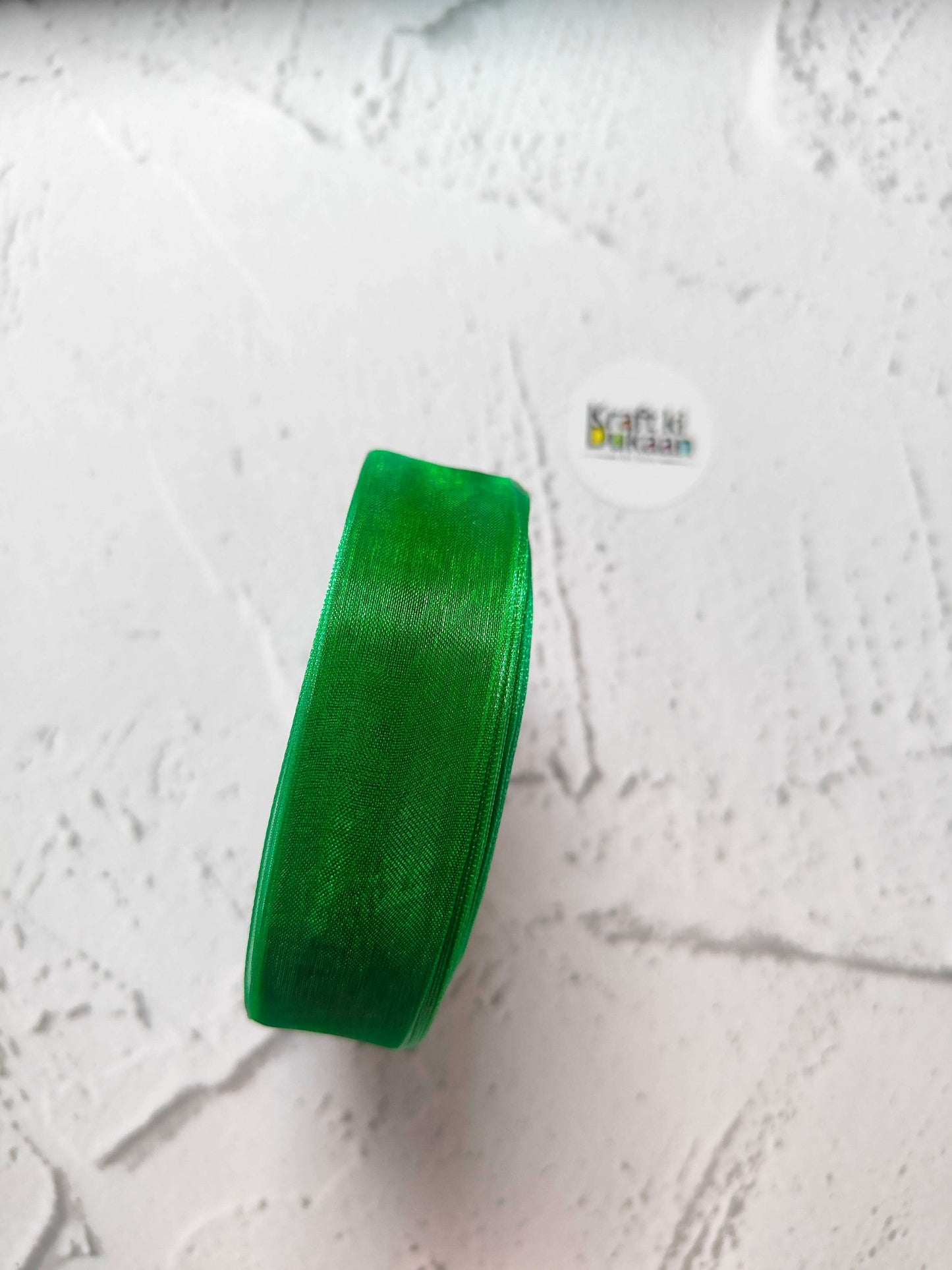 Organza ribbon roll in green, narrow woven fabric texture