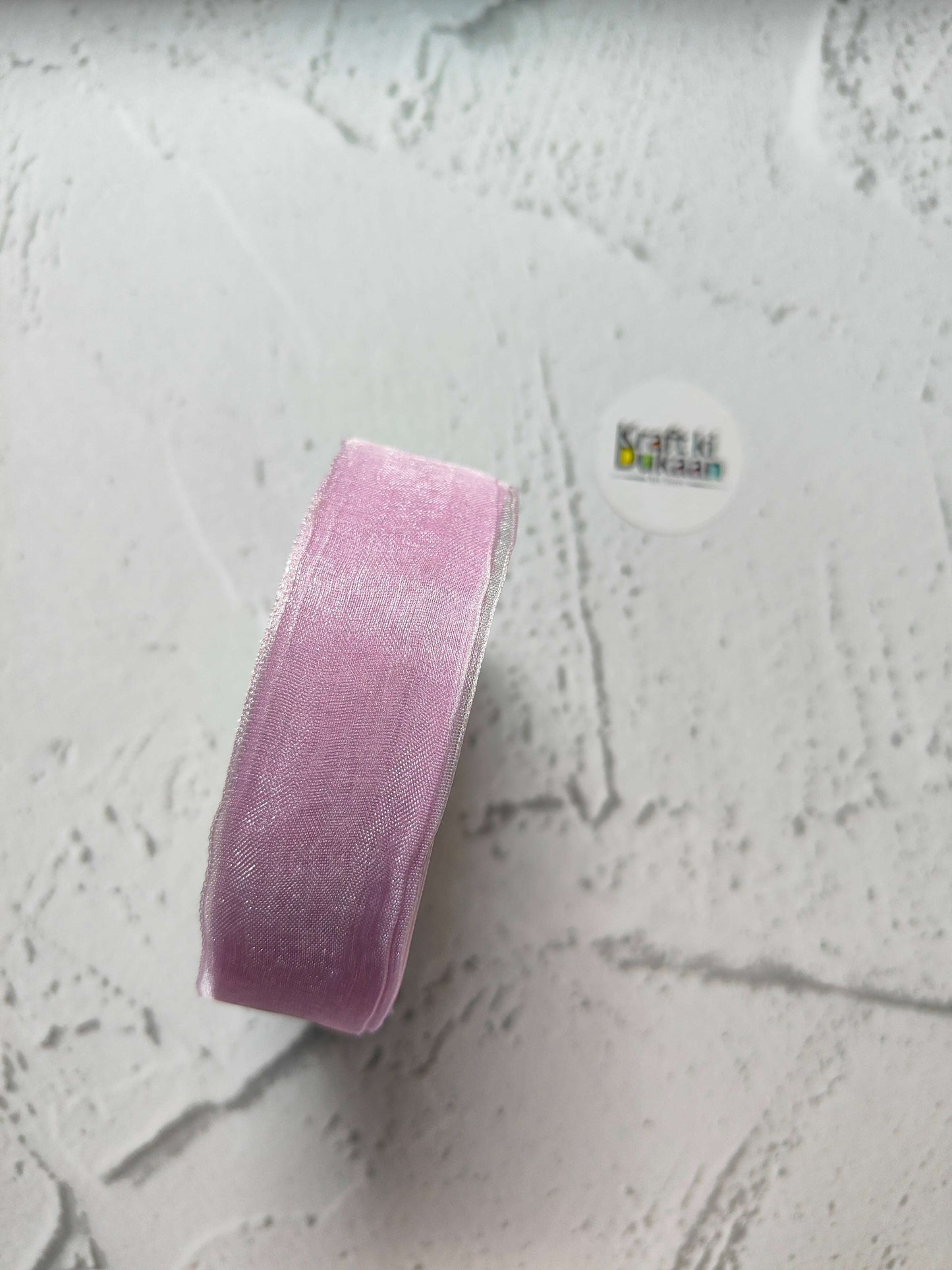 Lavender organza ribbon roll, narrow sheer strip with woven texture.