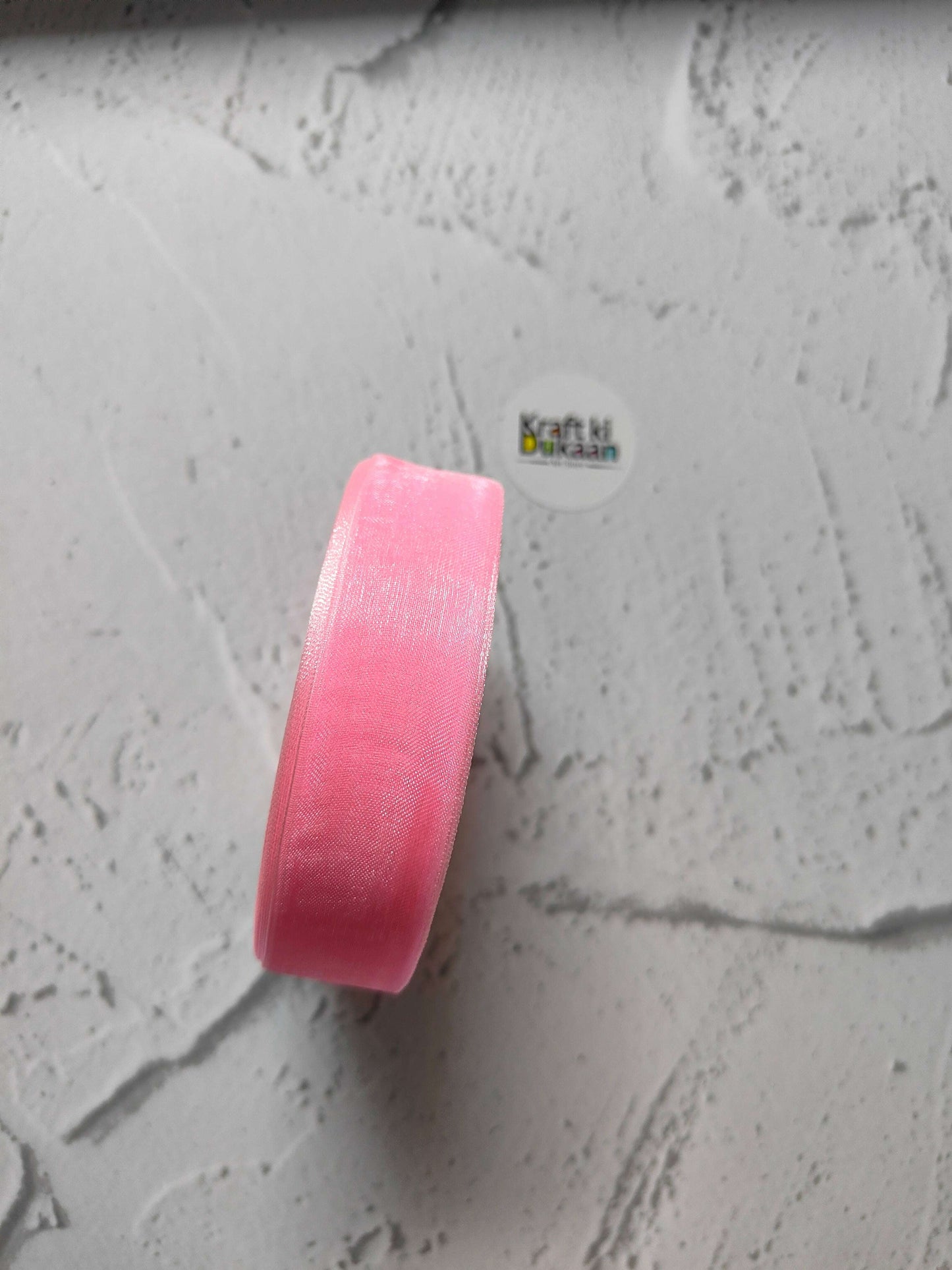 Organza ribbon roll in pink, narrow woven fabric texture