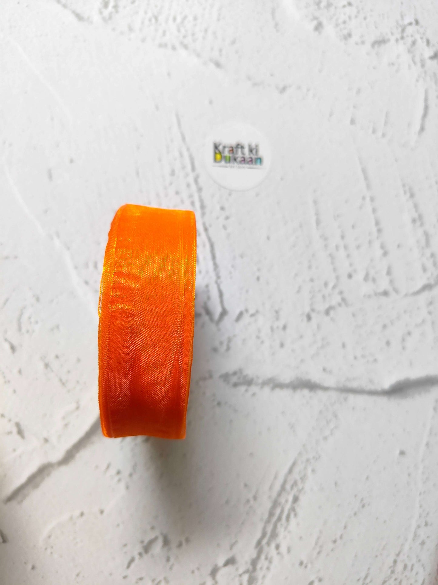 Organza ribbon roll in orange, narrow woven fabric texture