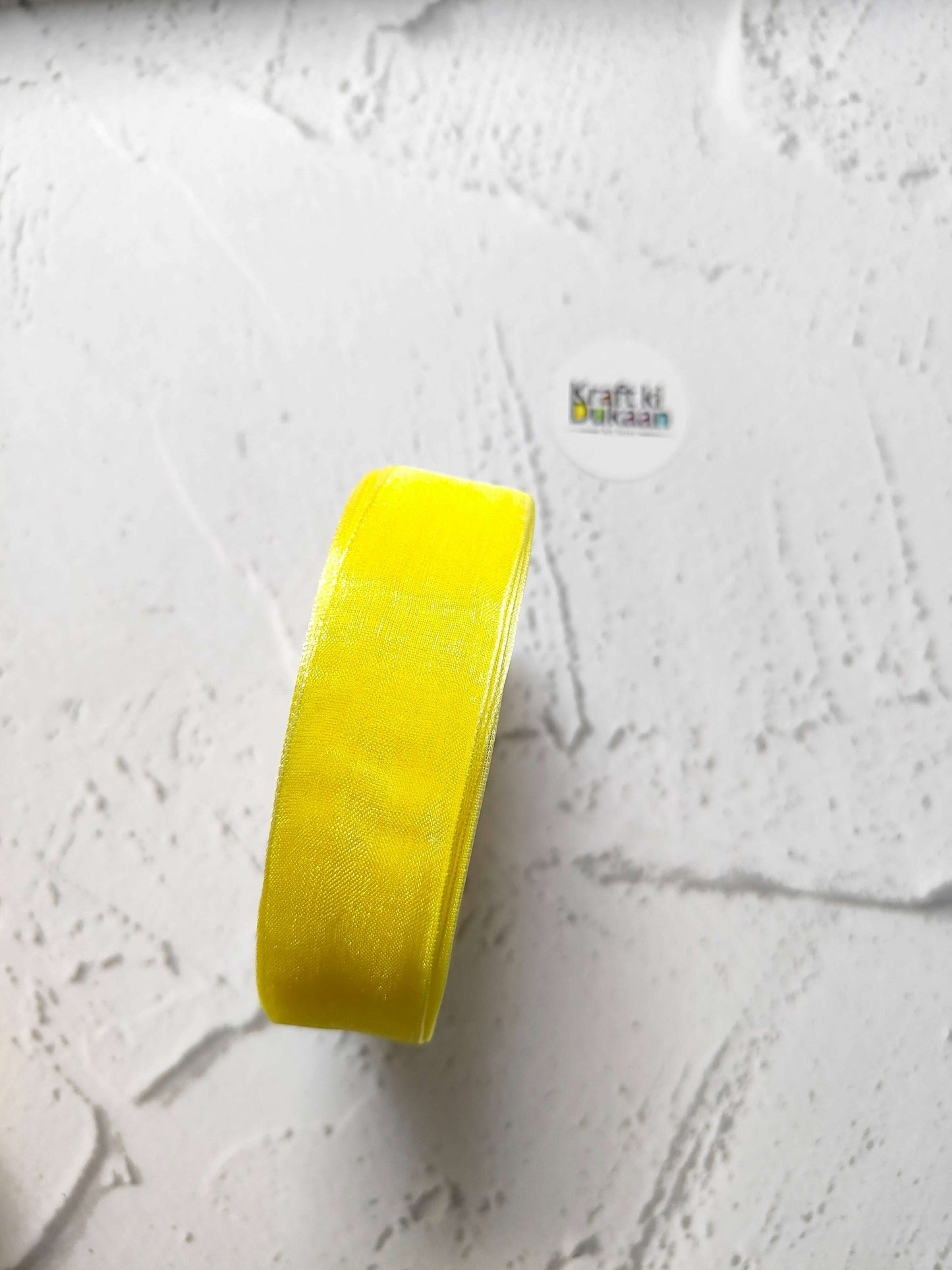 Organza ribbon roll in yellow, narrow woven fabric texture