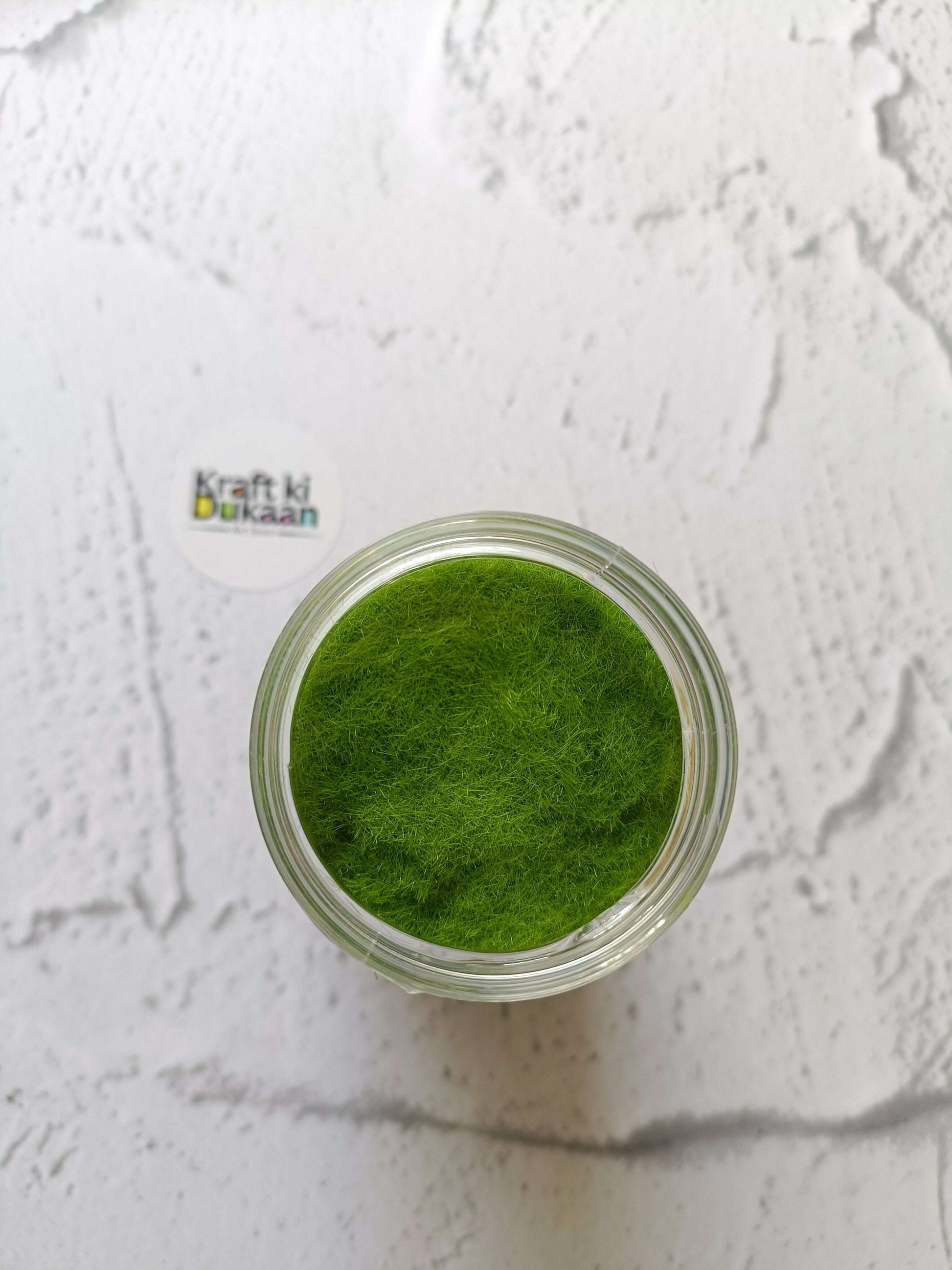 Artificial Grass 40GM light green fibers in an open-top clear jar, viewed from above