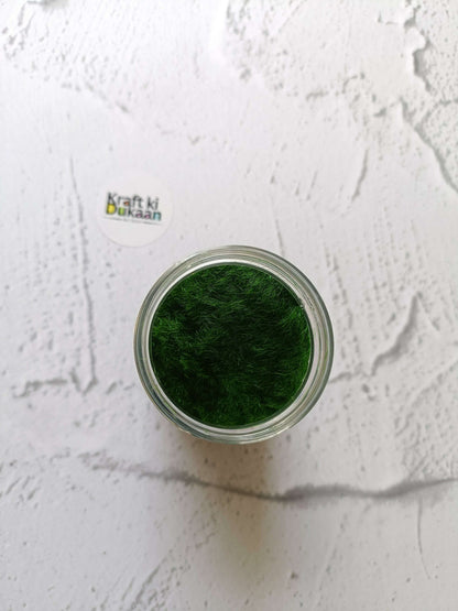 Artificial Grass 40GM dark green fibers in an open-top clear jar, viewed from above