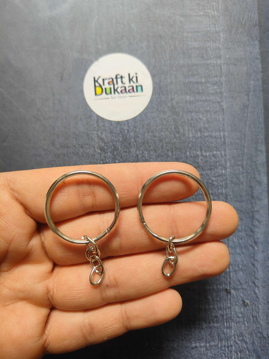 Silver round keychain ring on hand, with short chain and small clasp charm