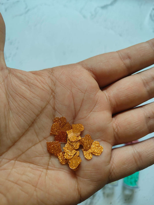 Gold star-shaped sequins on open palm; small glitter pieces