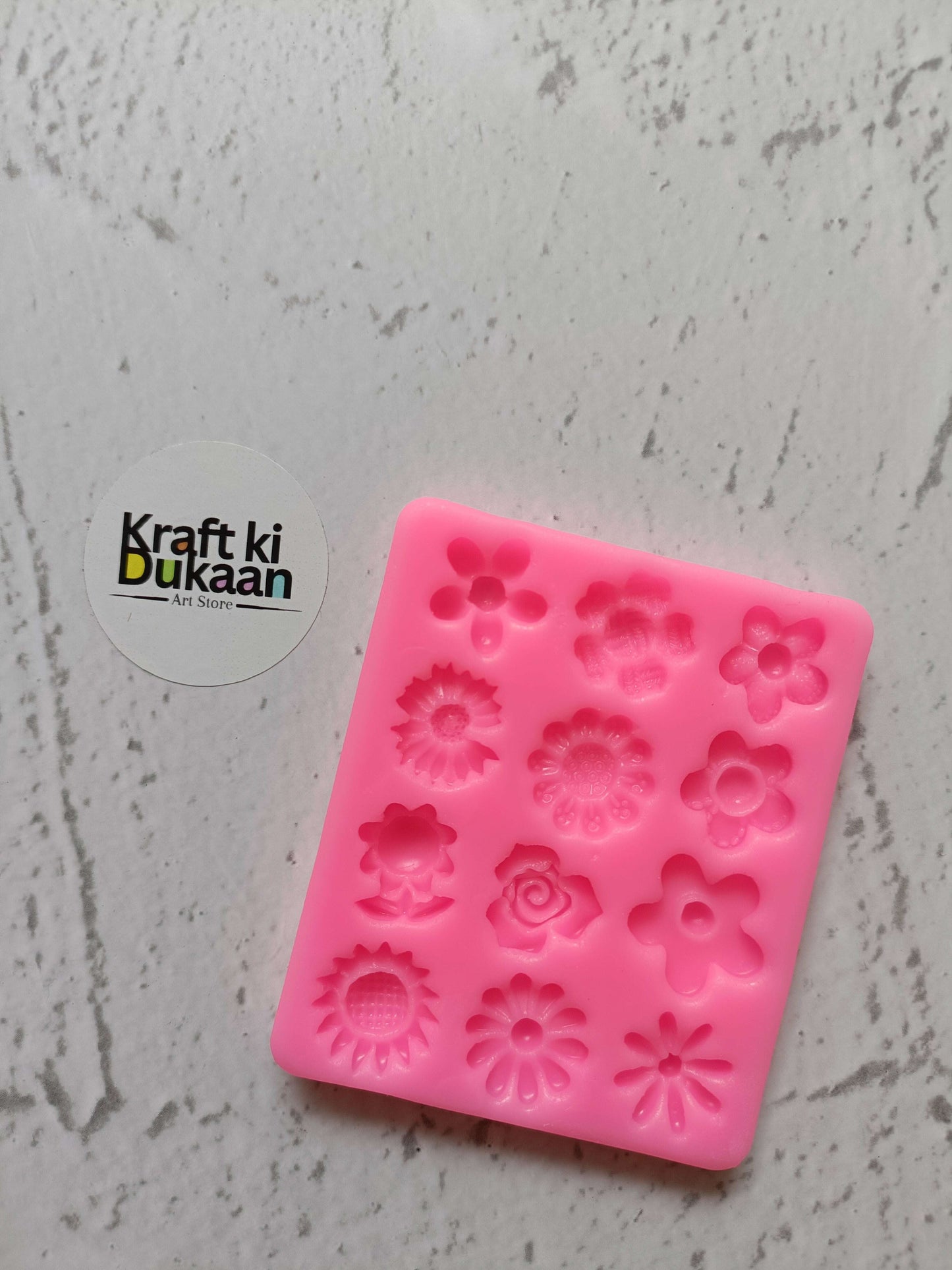 Pink 12-cavity flower silicone mould with embossed floral shapes, square tray