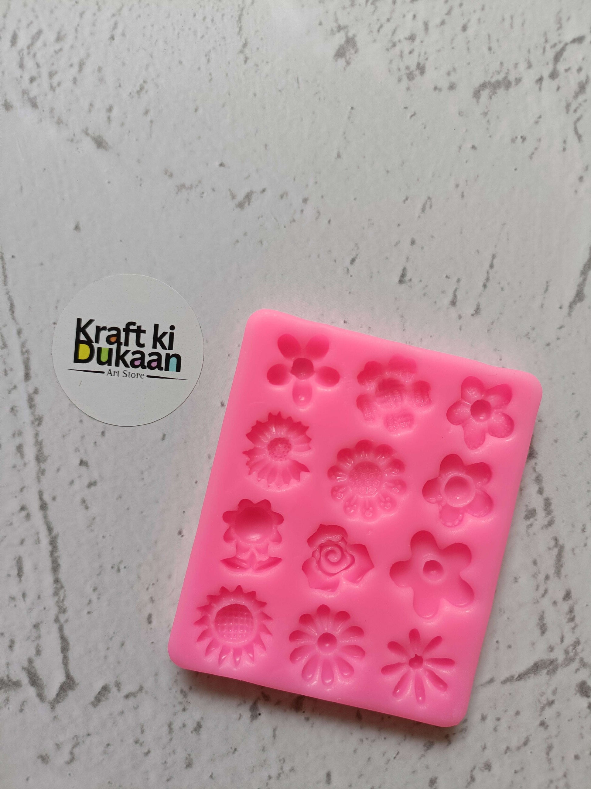 Pink 12-cavity flower silicone mould with embossed floral shapes, square tray