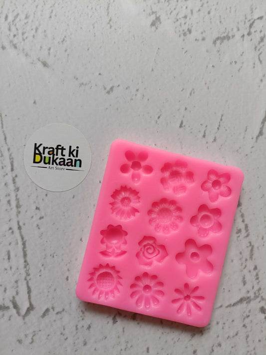 Pink 12-cavity flower silicone mould with embossed floral shapes, square tray