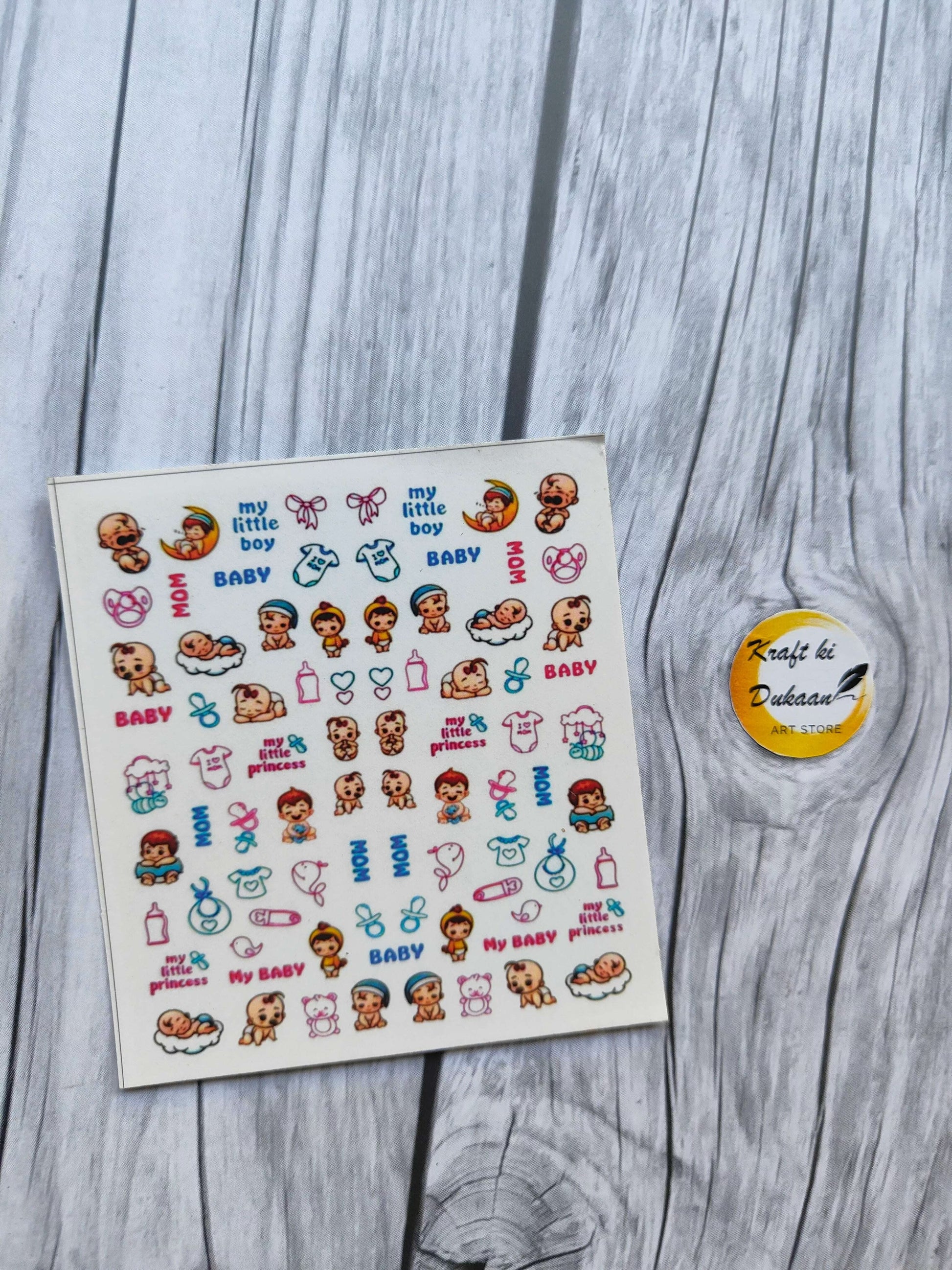 Colorful mini sticker sheet for keychain featuring various baby-themed designs and playful illustrations